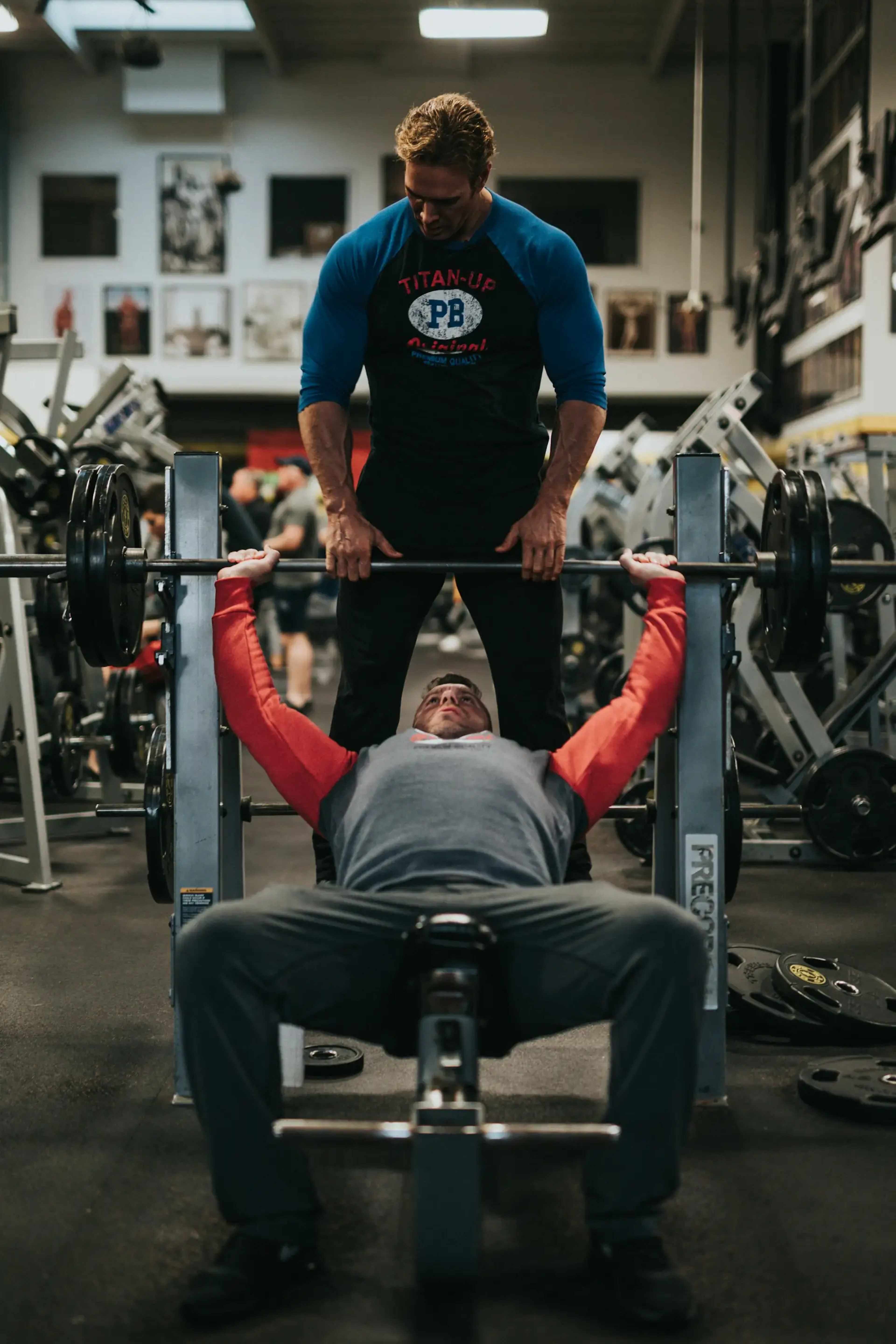 a man spotting another man on the benchpress